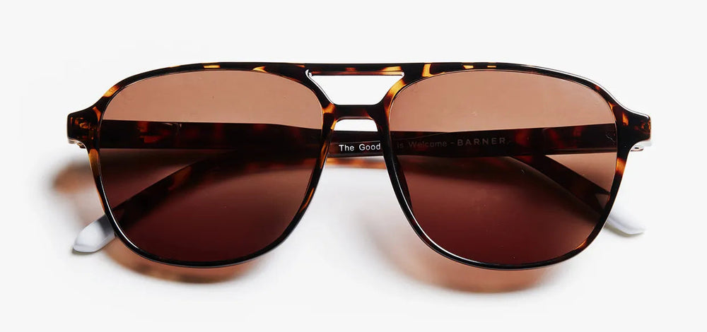 Sunglasses with tortoiseshell frame and brown lenses on a white background