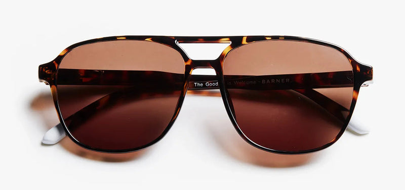 Sunglasses with tortoiseshell frame and brown lenses on a white background